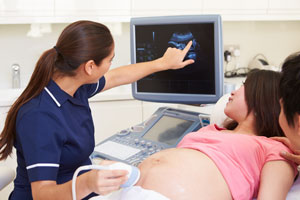 Eine Frauenärzting macht bei der Schwangeren einen Ultraschall und erklärt genau was zu sehen ist